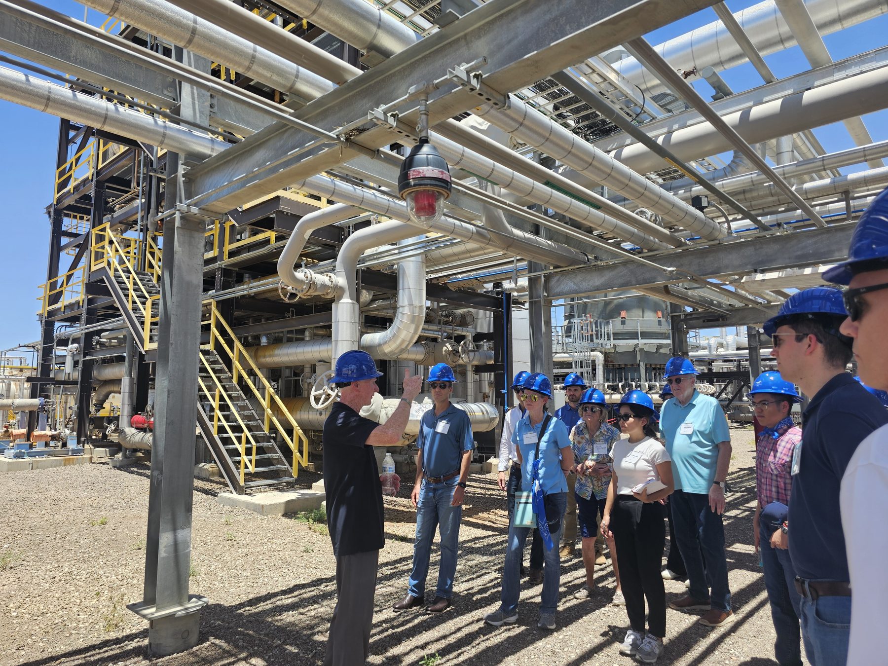 Infinium staff walking visitors in hard hats through the process racks at Project Roadrunner